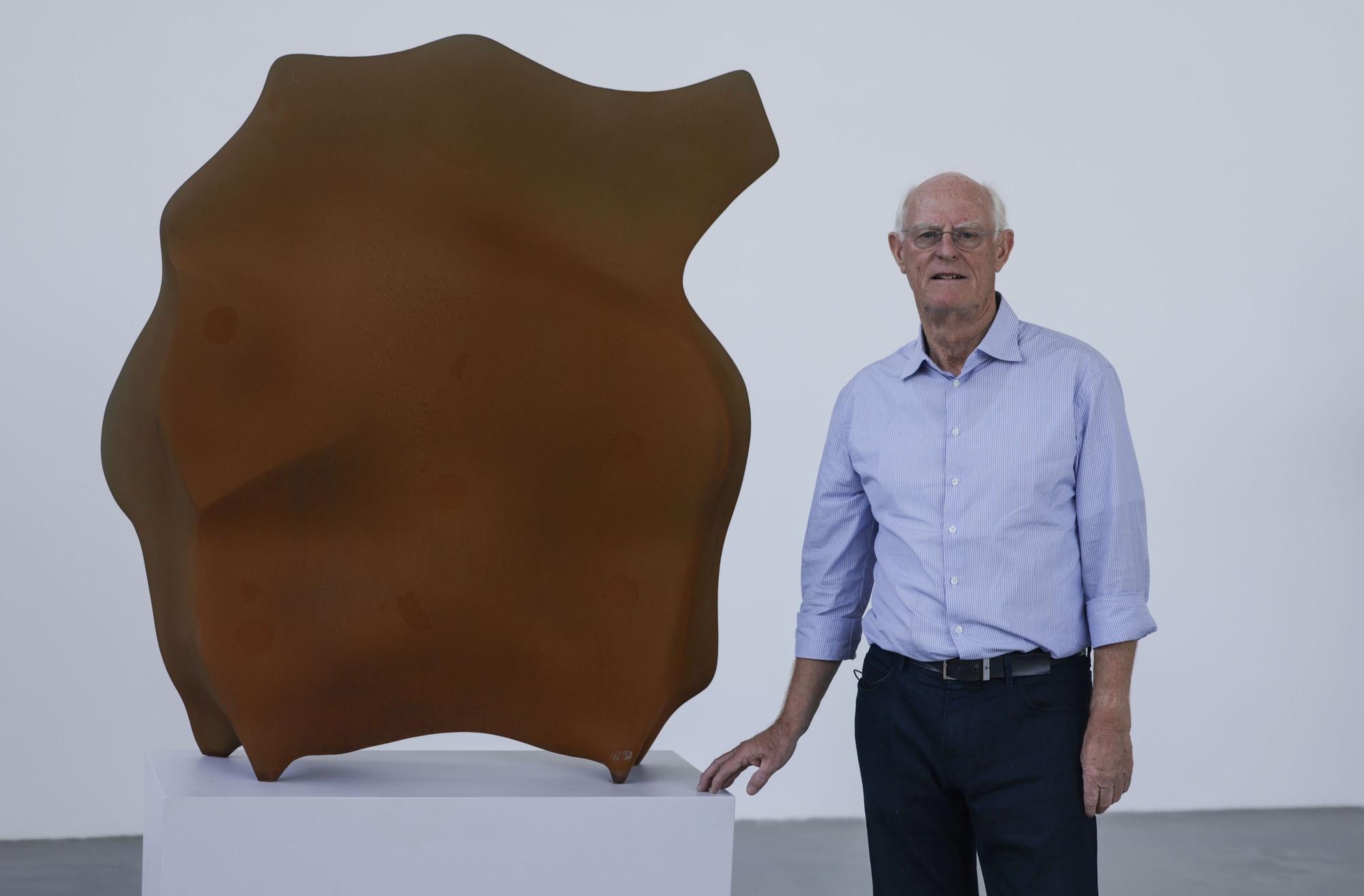 Der Künstler Tony Cragg steht neben seiner Skulptur „Stand“.
