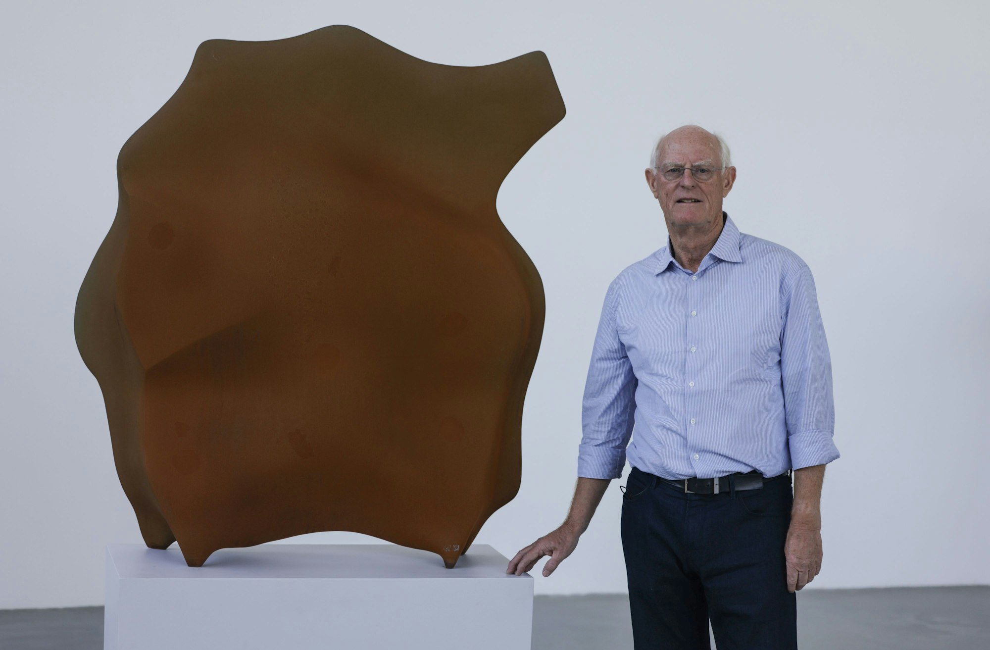 Der Künstler Tony Cragg steht neben seiner Skulptur „Stand“.