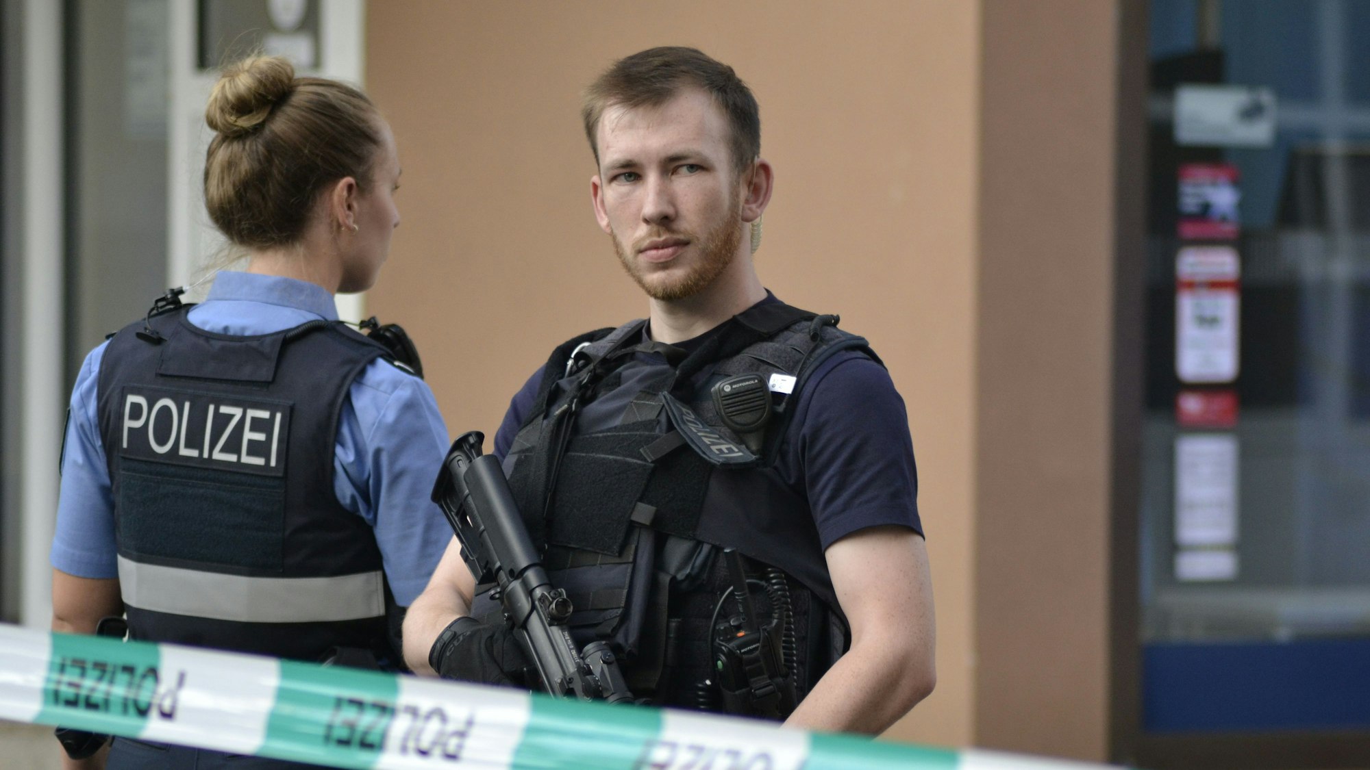 Das Bild zeigt einen Polizisten mit einem Maschinengewehr am Tatort und sichert den Bereich. Foto: Gianni Gattus/dpa