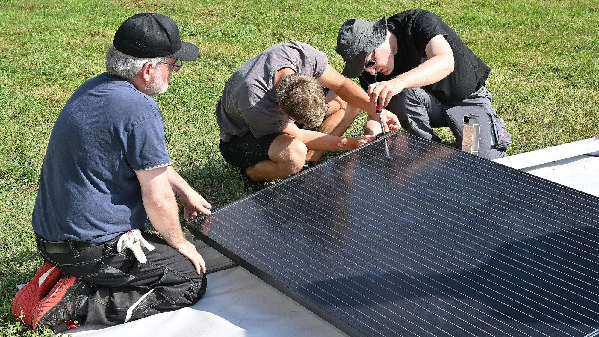 Zwei Jugendliche überprüfen die Ausmaße unter der Aufsicht eines Experten.