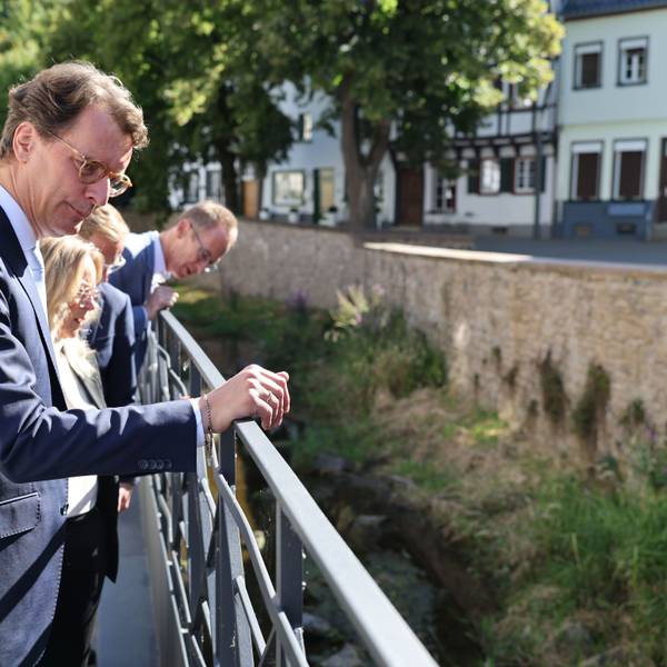 An der Erft lässt sich Hendrik Wüst erklären, mit welchen Maßnahmen künftig Hochwasser aus der Innenstadt gehalten werden kann.