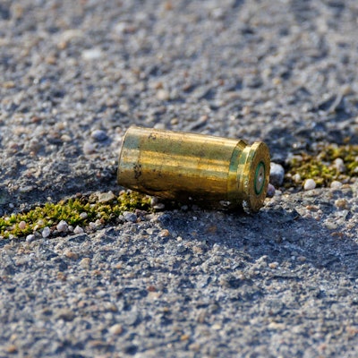 Das Bild zeigt eine Patronenhülse auf der Straße.