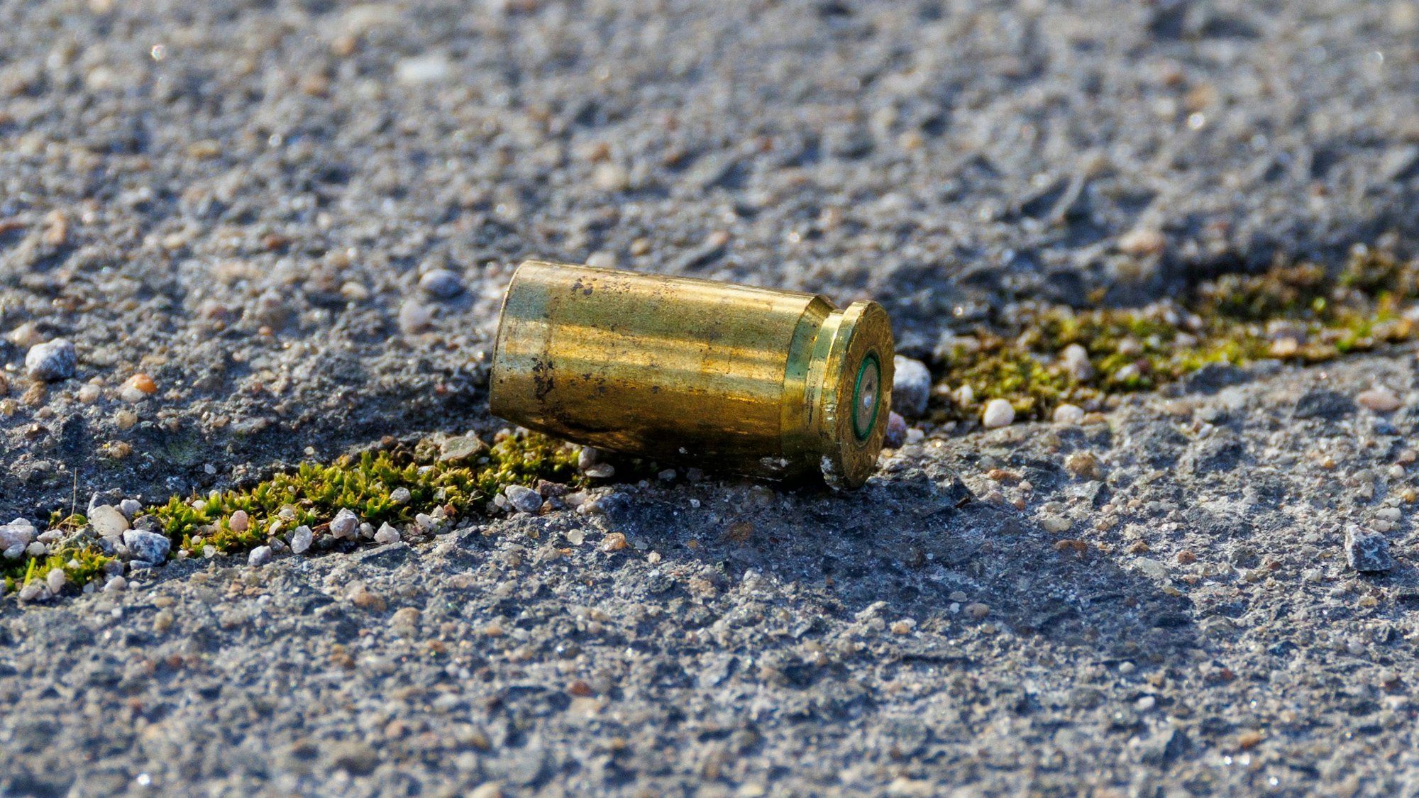 Eine Patronenhülse aus einer Waffe liegt auf dem Boden eines Parkplatzes.