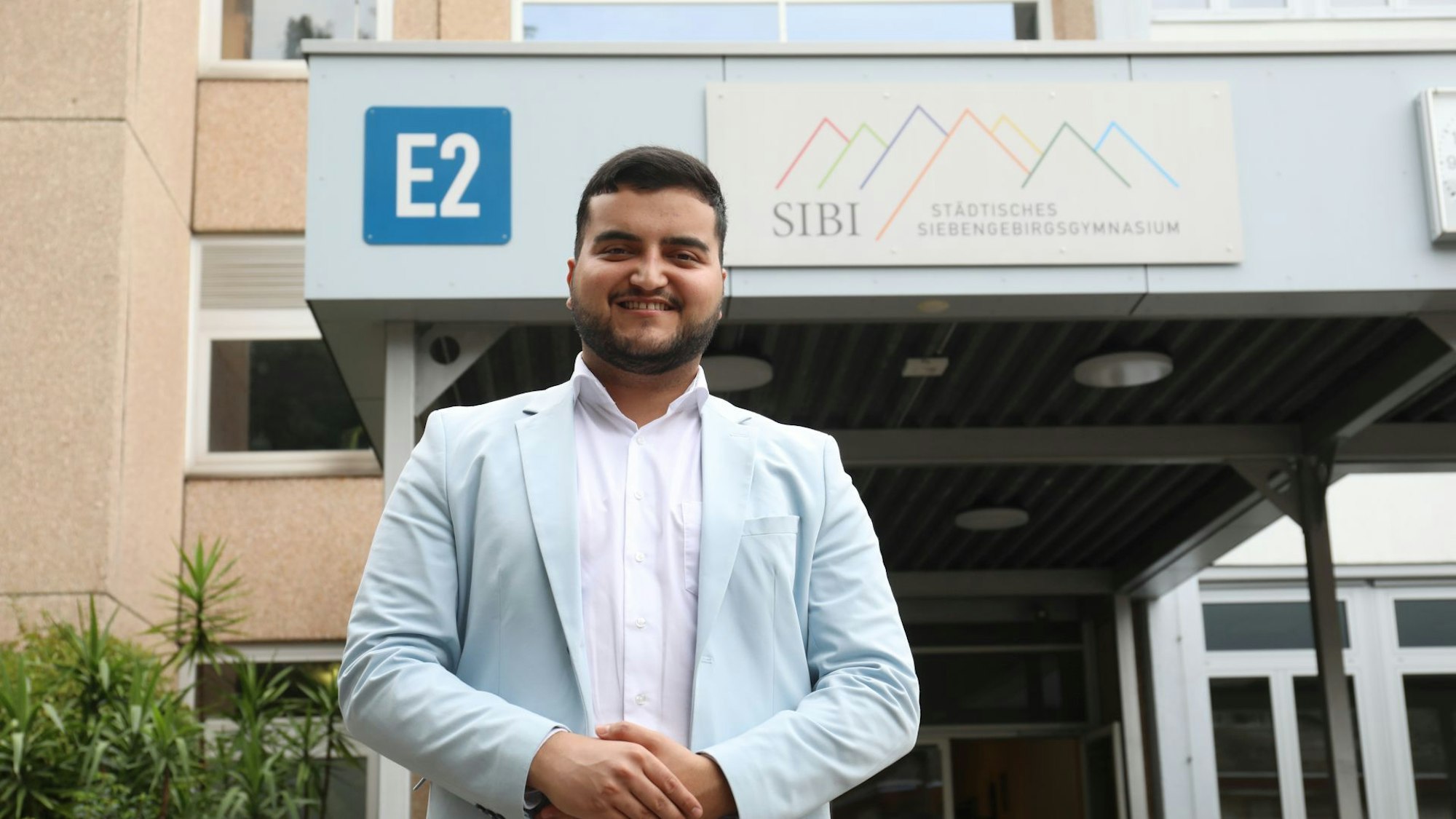 Ein junger Mann in blauem Sakko am Eingang zum Siebengebirgsgymnasium.
