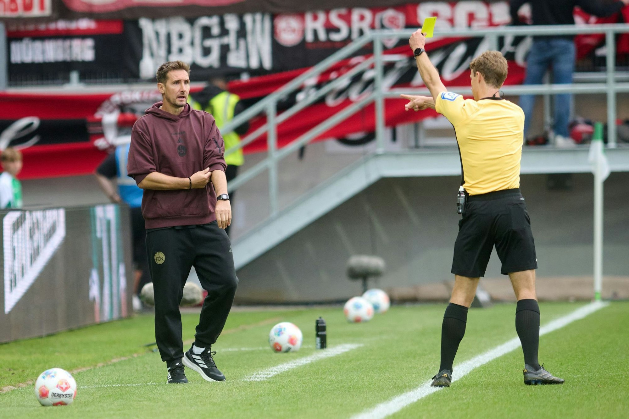 Kein guter Abend für Nürnbergs Trainer Miroslav Klose - diese Gelbe Karte durch Schiedsrichter Jarno Wienefeld aber erhielt sein Co-Trainer Javier Pinola hinter ihm.