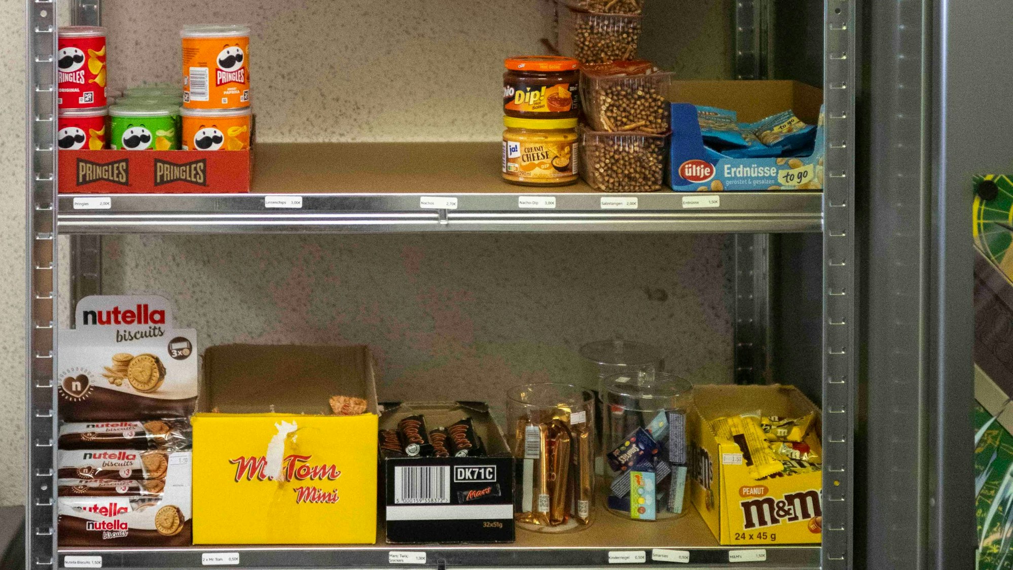 In einem Regal lagern Süßigkeiten und salzige Knabbereien.
