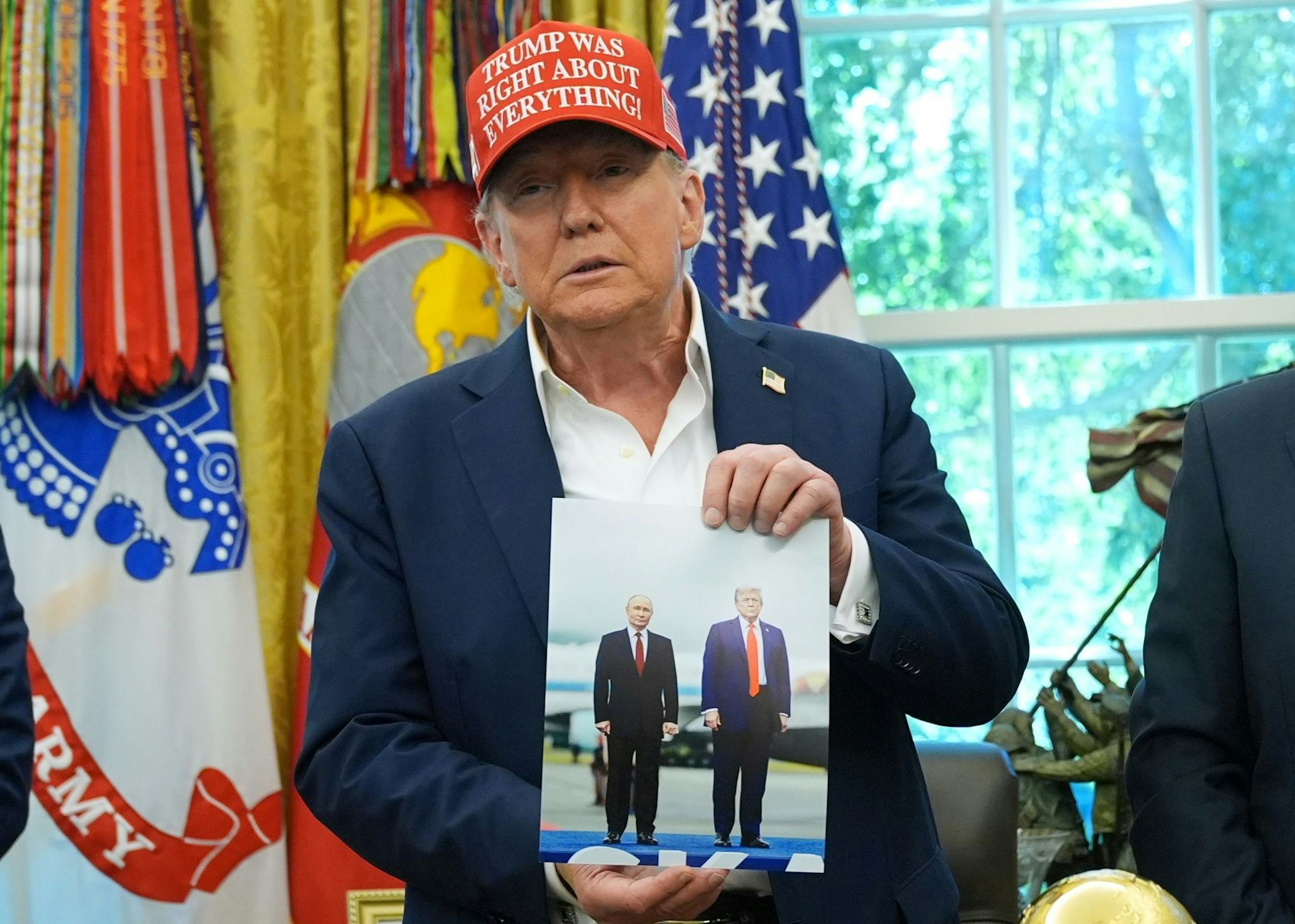 Trump zeigt ein Foto von sich und Putin.