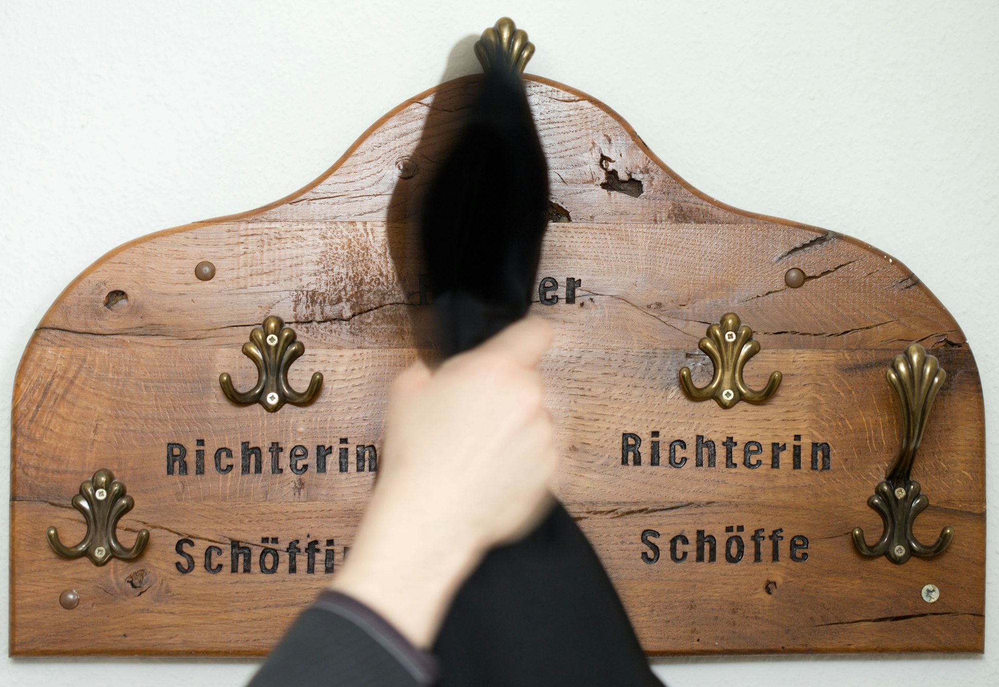Ein Richter hängt seine Robe an eine Garderobe für Richter und Schöffen.