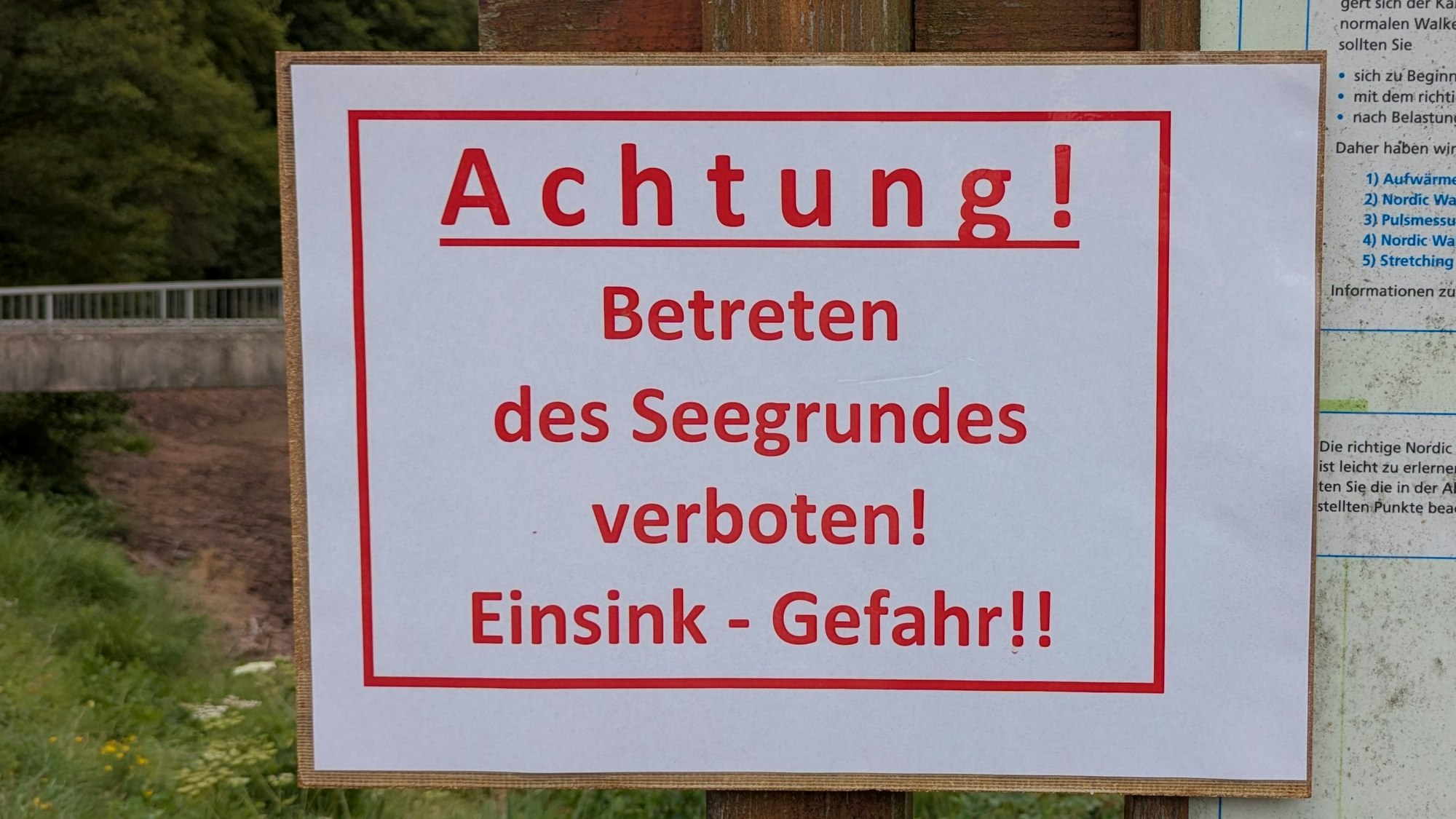 Auf einem Schild steht in roter Farbe: „Achtung! Betreten des Seegrundes verboten! Einsink-Gefahr!!“