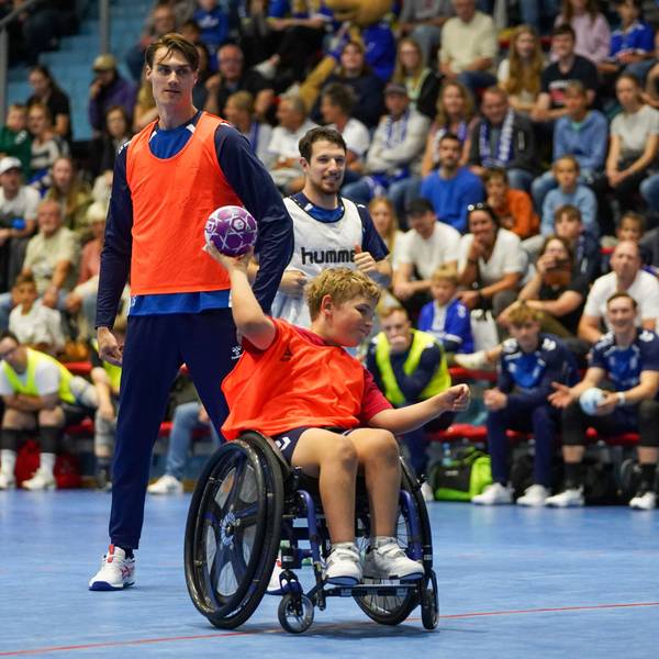 Miro Schluroff und Joao Gomes beobachten, wie ein Junge im Roll den Handball Richtung Tor wirft.