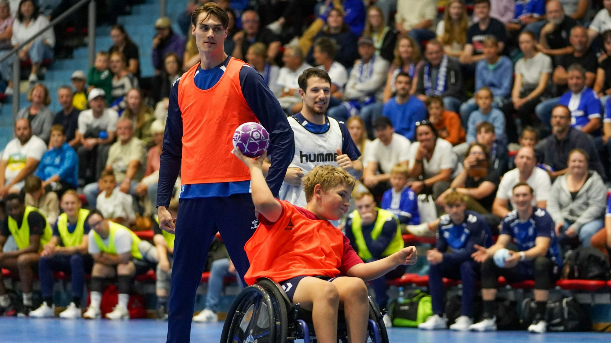 Miro Schluroff und Joao Gomes beobachten, wie ein Junge im Roll den Handball Richtung Tor wirft.