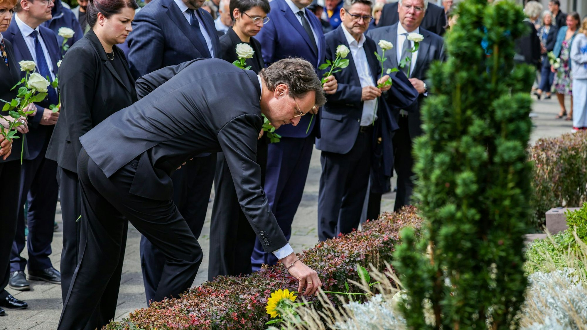 Hendrik Wüst (CDU), Ministerpräsident von Nordrhein-Westfalen, legt eine weiße Rose am Gedenkstein zum Terroranschlag in Solingen ab.