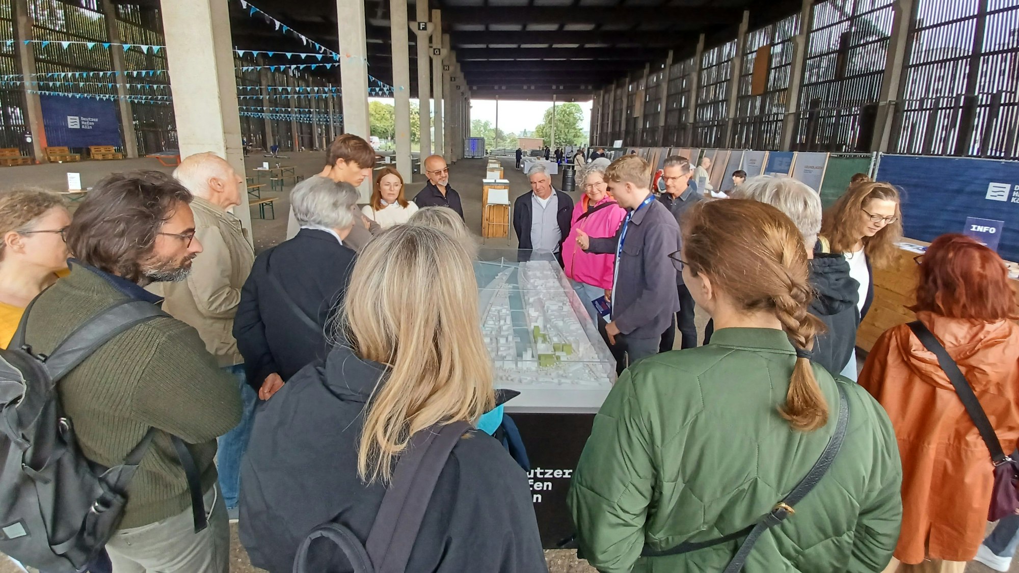 Menschen stehen um ein Stadtmodell herum.