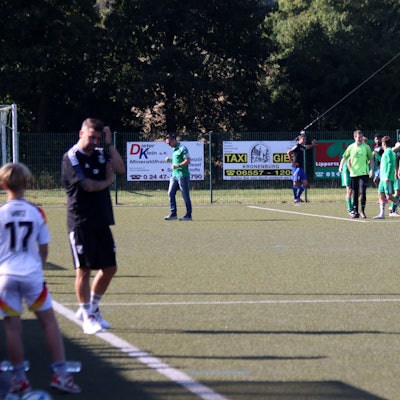 Die Sötenicher jubeln nach der 4:3-Führung. Im Vordergrund ist unscharf Dahlems Trainer Christian Hammes zu erkennen, der sich am Kopf kratzt.