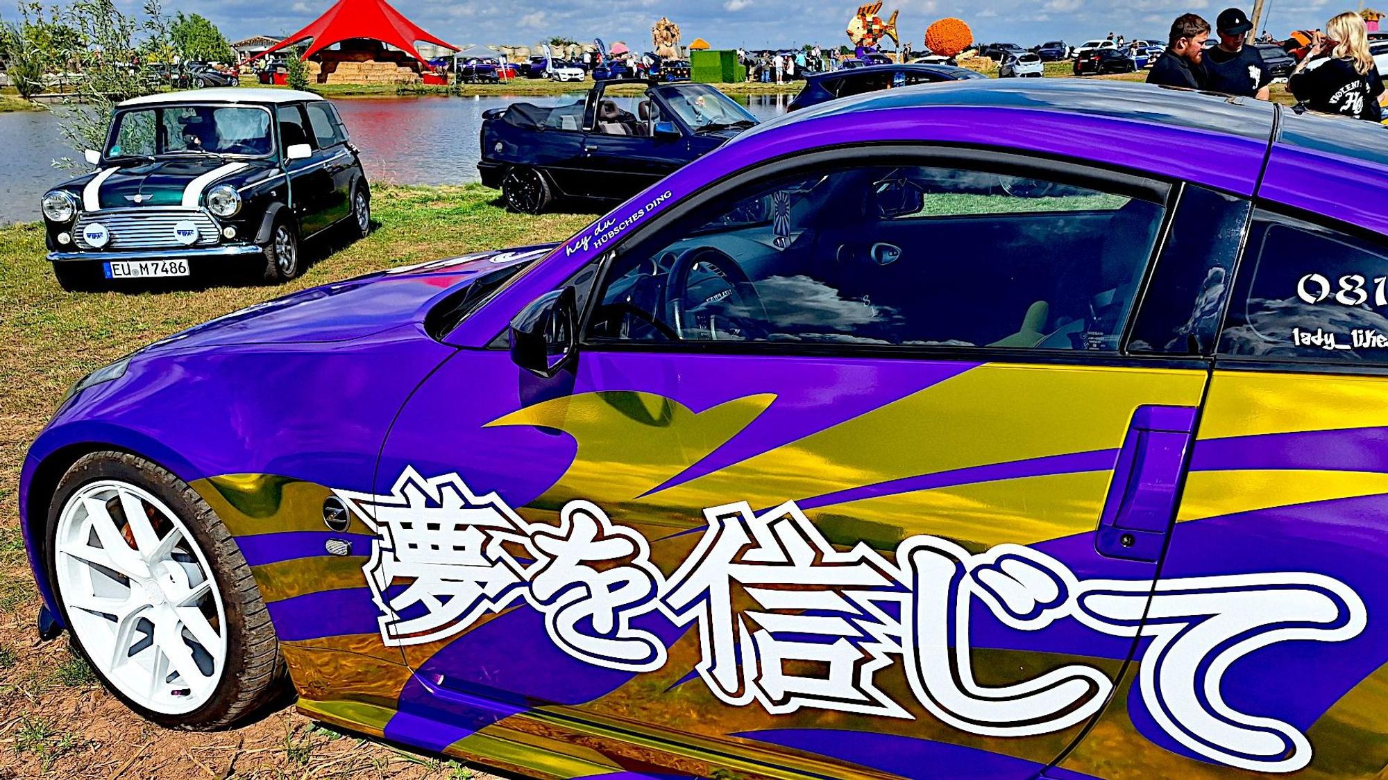 Ein Auto ist mit goldener Folie und asiatischen Schriftzeichen beklebt. Im Hintergrund stehen weitere Fahrzeuge.