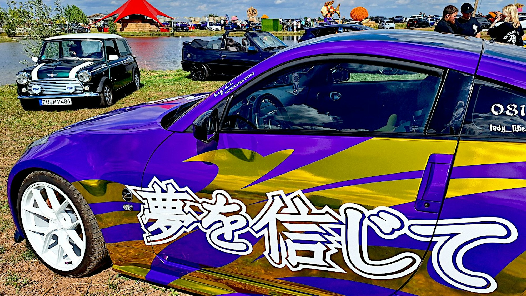 Ein Auto ist mit goldener Folie und asiatischen Schriftzeichen beklebt. Im Hintergrund stehen weitere Fahrzeuge.