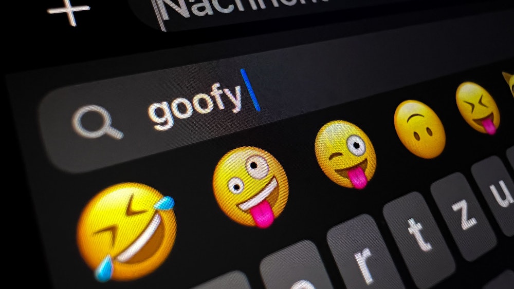 Im Display eines Smartphones ist im Suchfeld für Smileys das Wort „goofy“ (komisch, tollpatschig) zu lesen.