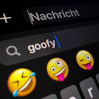 Im Display eines Smartphones ist im Suchfeld für Smileys das Wort „goofy“ (komisch, tollpatschig) zu lesen.