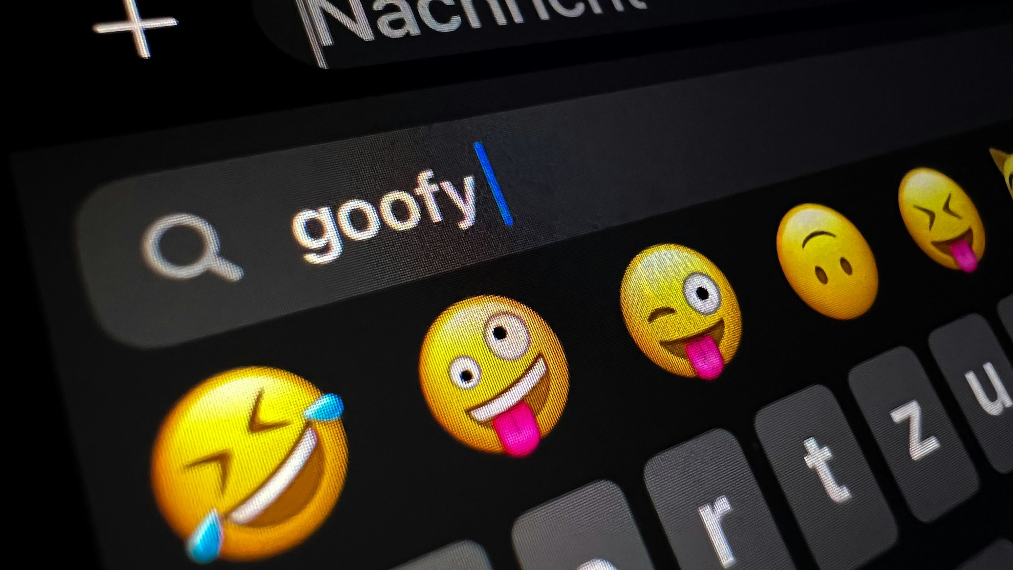 Im Display eines Smartphones ist im Suchfeld für Smileys das Wort „goofy“ (komisch, tollpatschig) zu lesen.