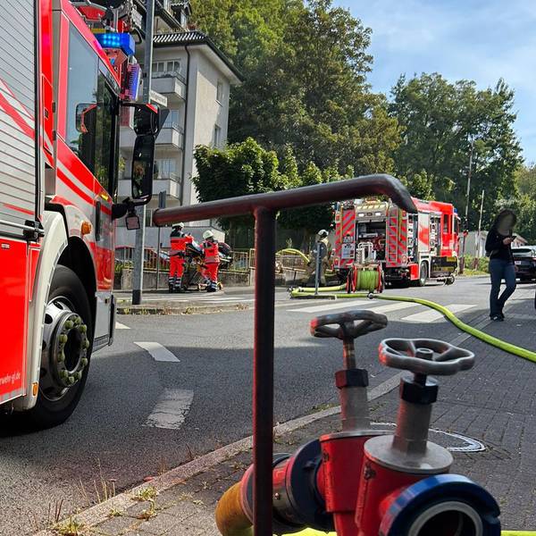 Feuerwehrfahrzeuge stehen an einem Wohn- und Geschäftshaus an der Kürtener Straße in Bergisch Gladbach.