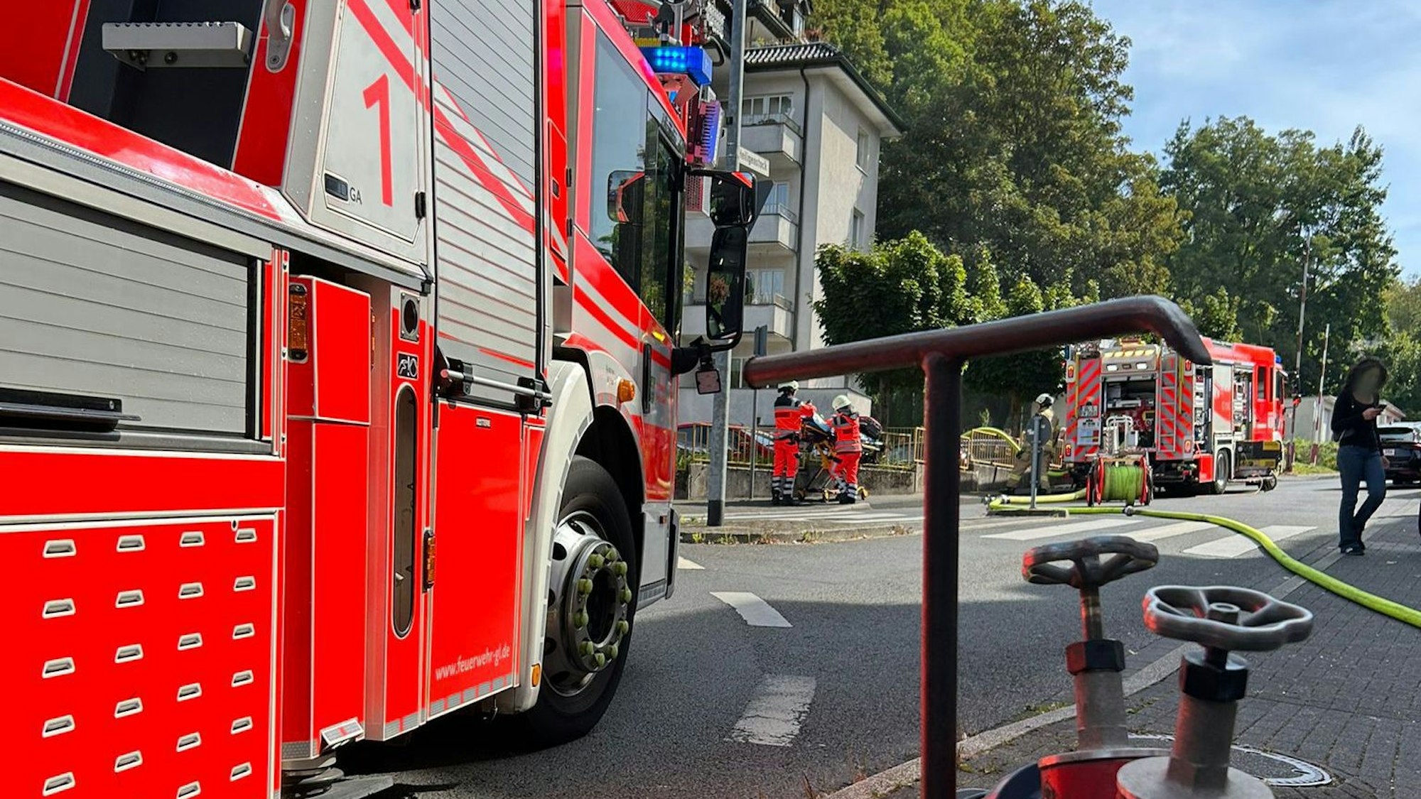 Feuerwehrfahrzeuge stehen an einem Wohn- und Geschäftshaus an der Kürtener Straße in Bergisch Gladbach.