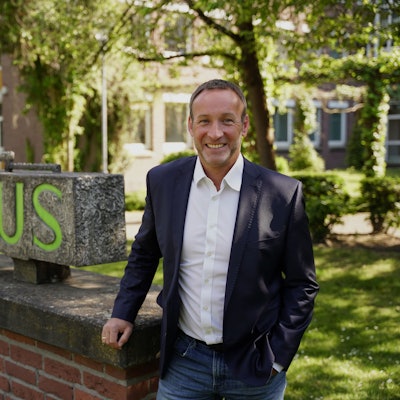 Ein Mann steht vor einem Rathaus.