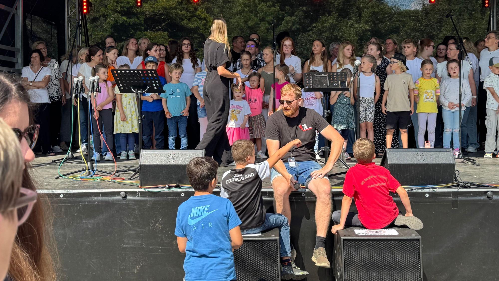 Auf dem Bild sind Kinder auf einer Bühne zu sehen.