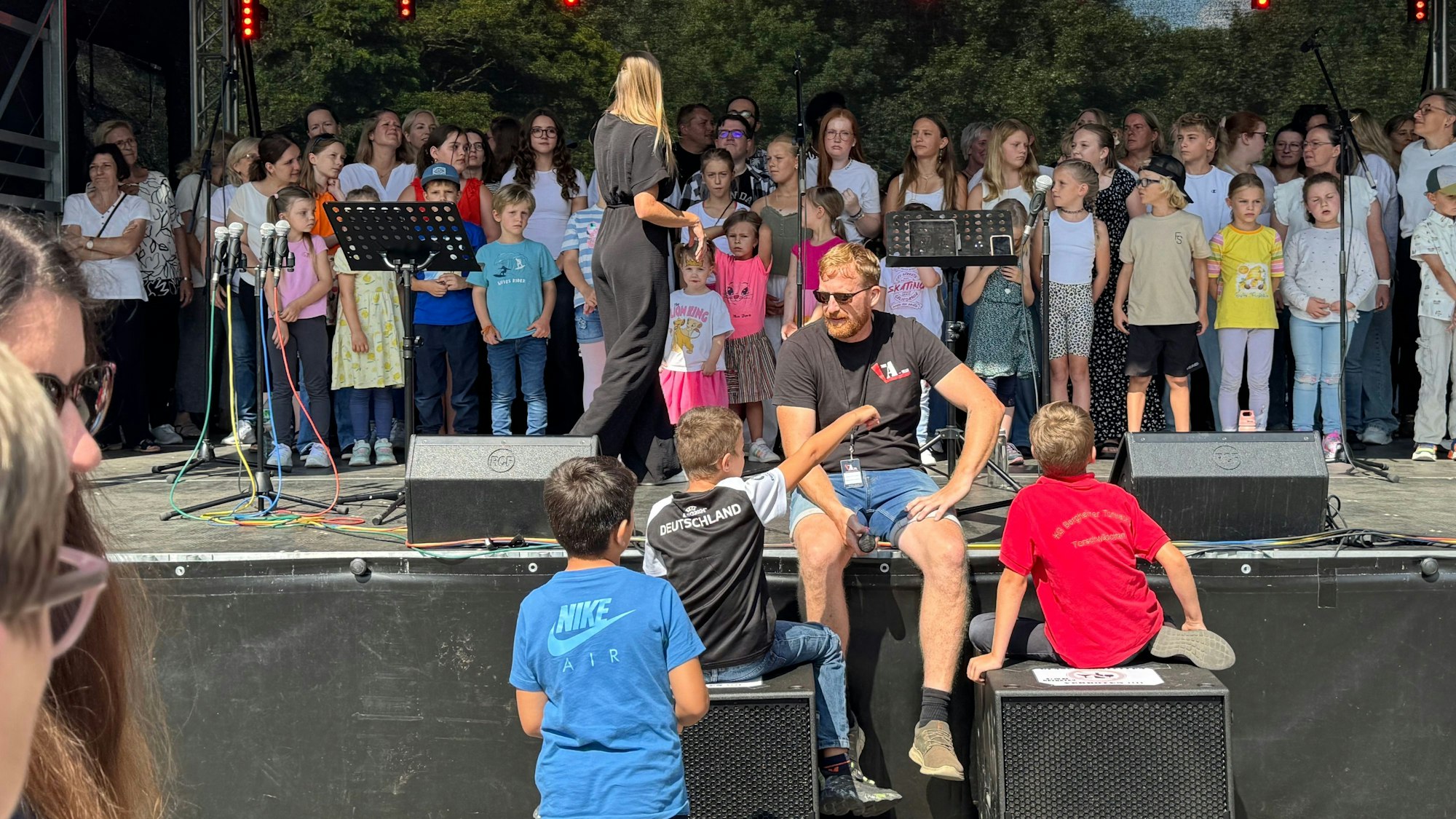 Auf dem Bild sind Kinder auf einer Bühne zu sehen.