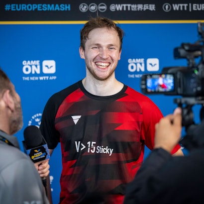 Benedikt Duda lacht bei der Pressekonferenz in die Kamera.