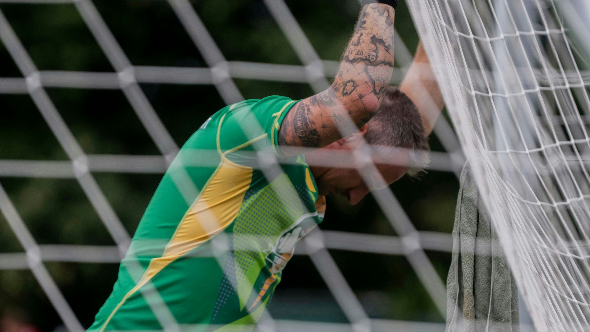 Torwart Markus Strick hat sich vom Spielfeld weggedreht und hält sich mit den Händen im Tornetz fest.