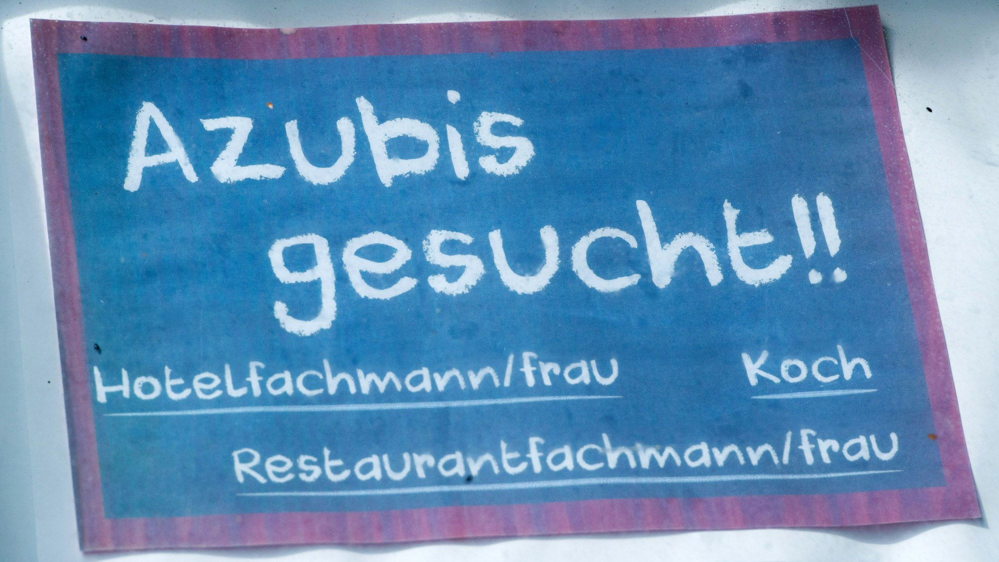 Vor einem Hotel hängt ein Schild mit dem Schriftzug «Azubis gesucht!!».