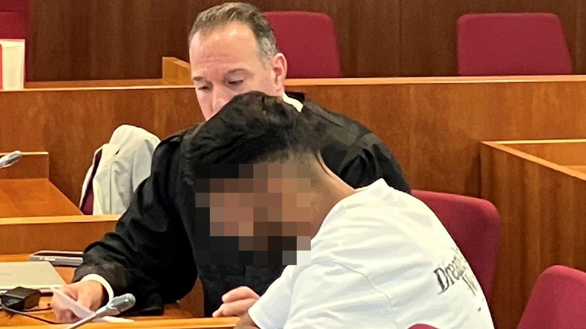 Das Bild zeigt den Angeklagten, dessen Gesicht unkenntlich gemacht wurde, und im Hintergrund einen Anwalt.