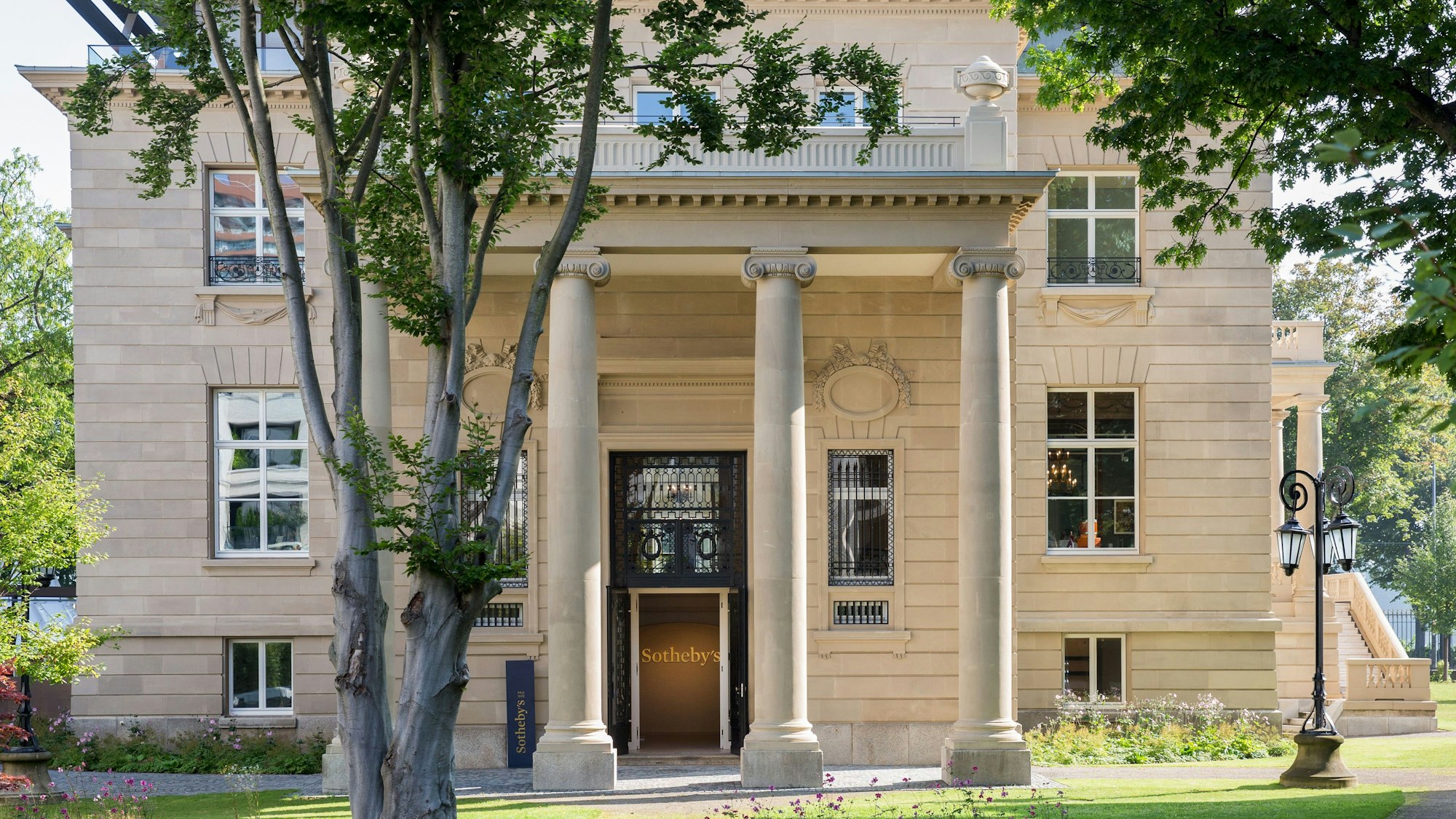 Eine prächtige alte Villa mit Säulen vor der mächtigen Tür ist zu sehen.