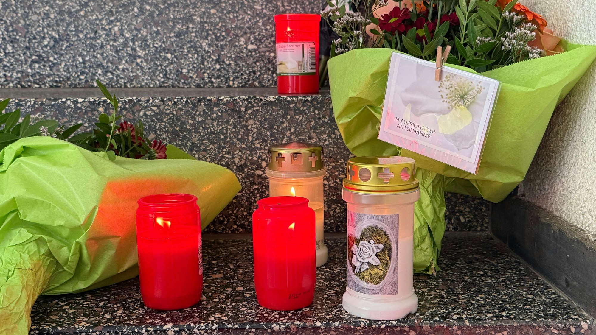 22.08.2025, Saarland, Völklingen: Blumen und Kerzen sind vor der Polizeiinspektion Völklingen abgelegt worden. Dort hatte der erschossene Polizist gearbeitet. Der Polizeibeamte starb im Einsatz nach einem Raubüberfall auf eine Tankstelle. Foto: Christian Schultz/dpa +++ dpa-Bildfunk +++