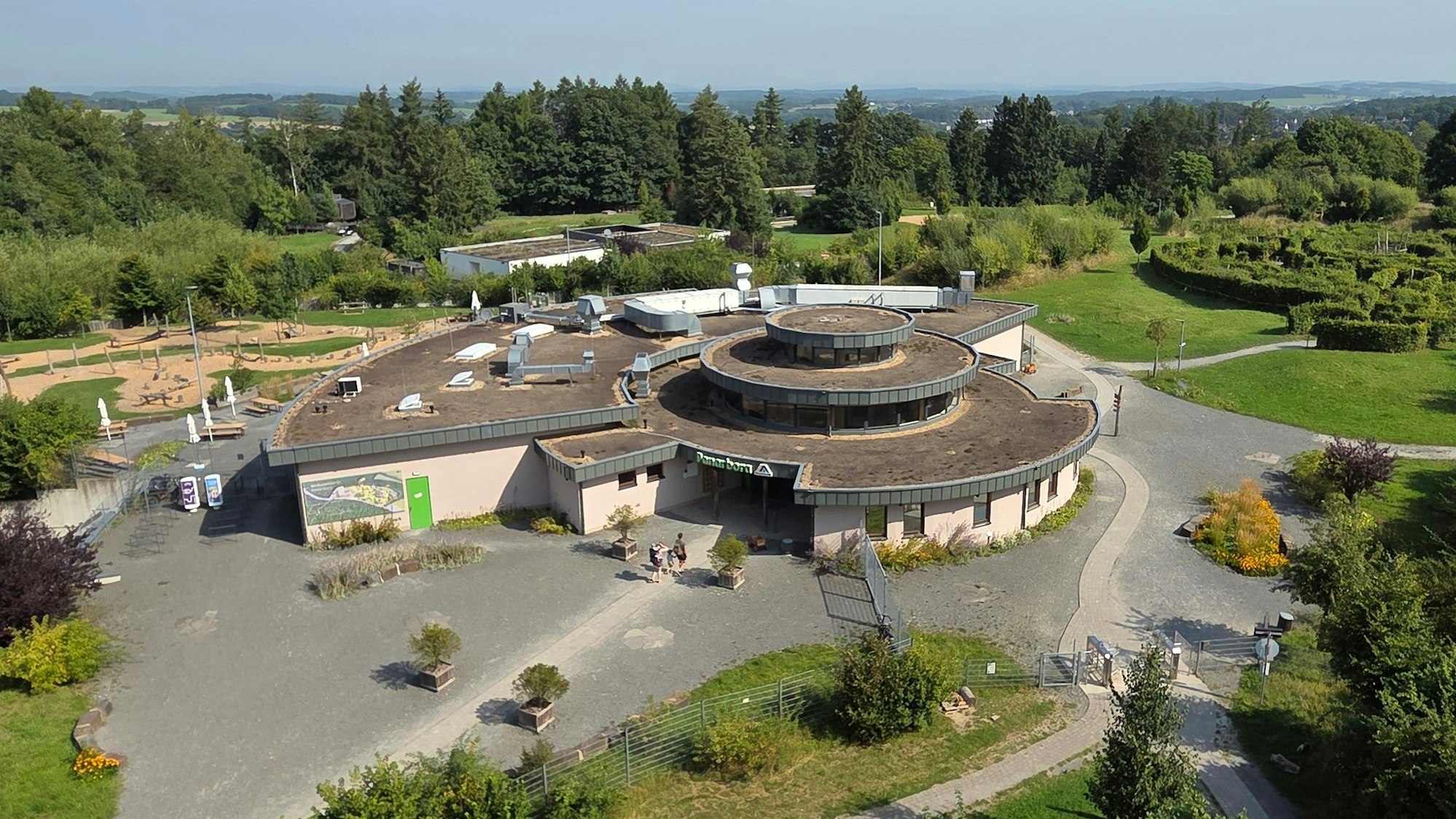 Blick vom hölzernen Aussichtsturm auf den Empfangspavillon des Waldbröler Naturerlebnisparks Panarbora: Das Ausflugshziel mit Jugendherberge wird im September zehn Jahre alt.