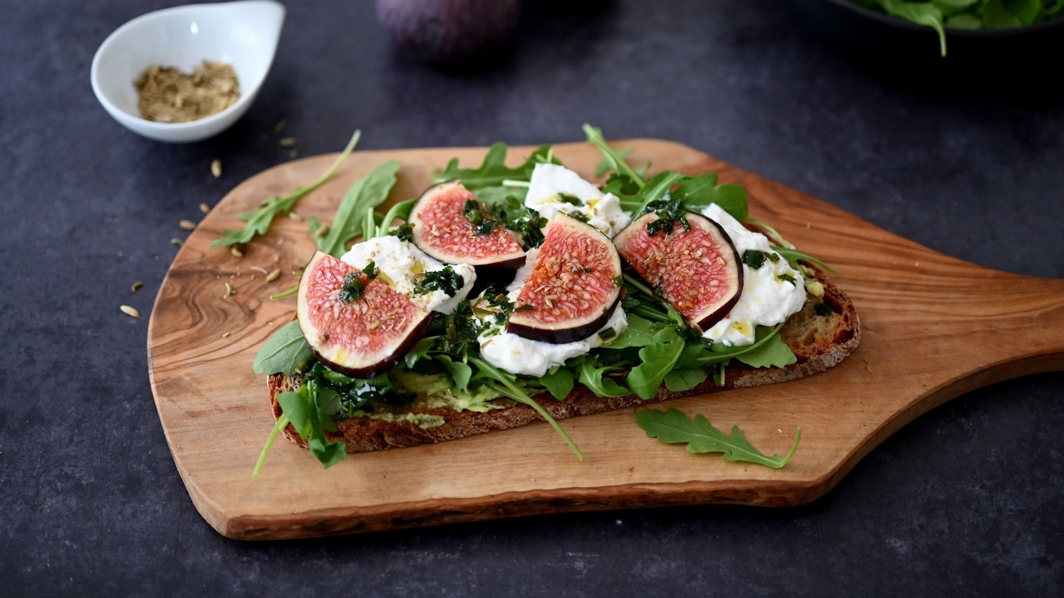 Das Butterbrot wird zunächst in der Pfanne knusprig angebraten. Belegt mit Rucola, Burrata und Feigen wird es zum Bauernbrot.