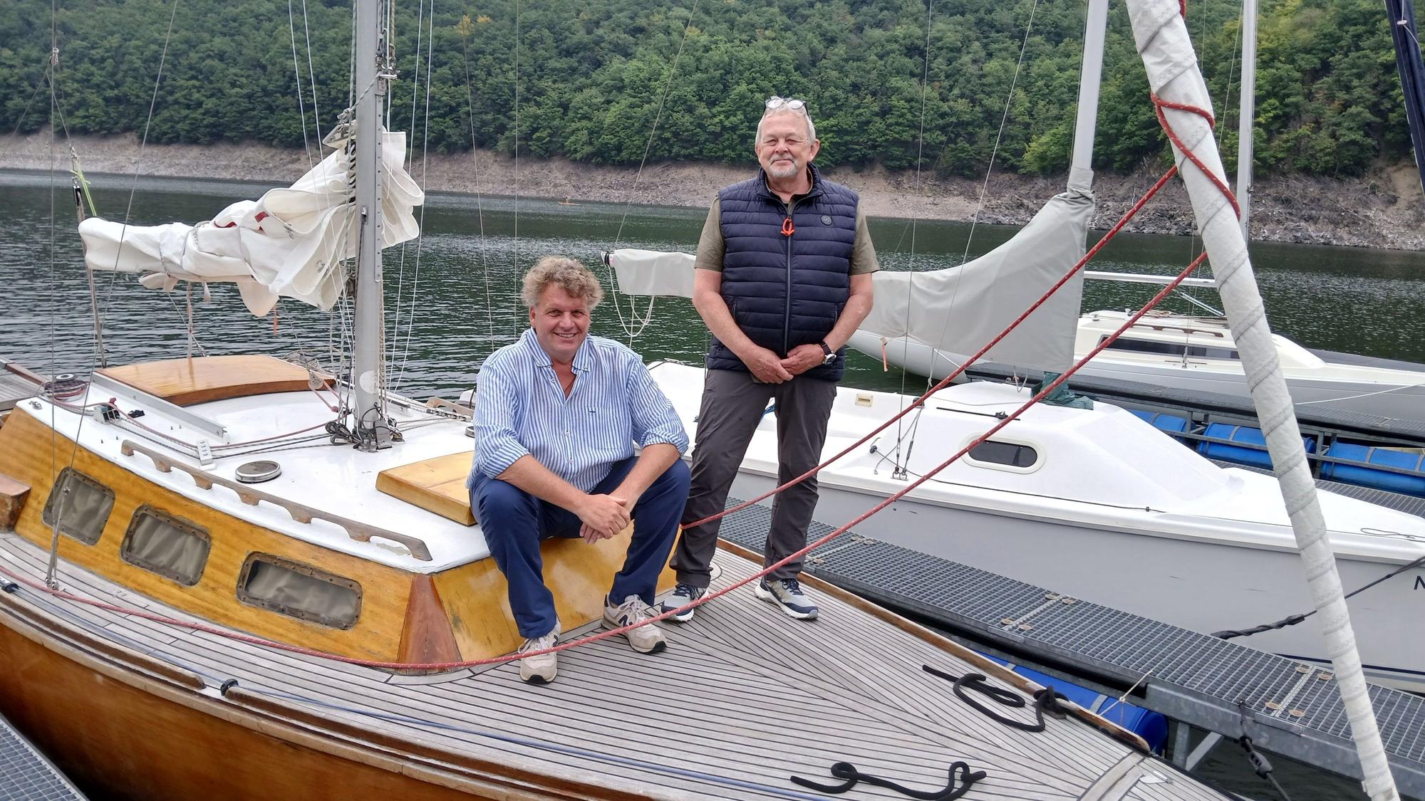 Das Bild zeigt zwei Männer auf einem Segelboot.
