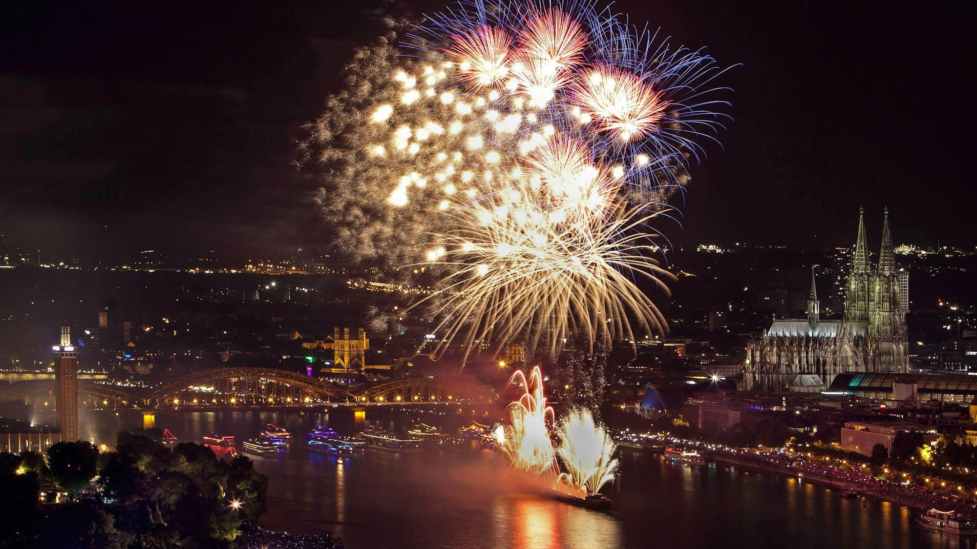Der Kölner Dom und der Rhein und ein Feuerwerk.