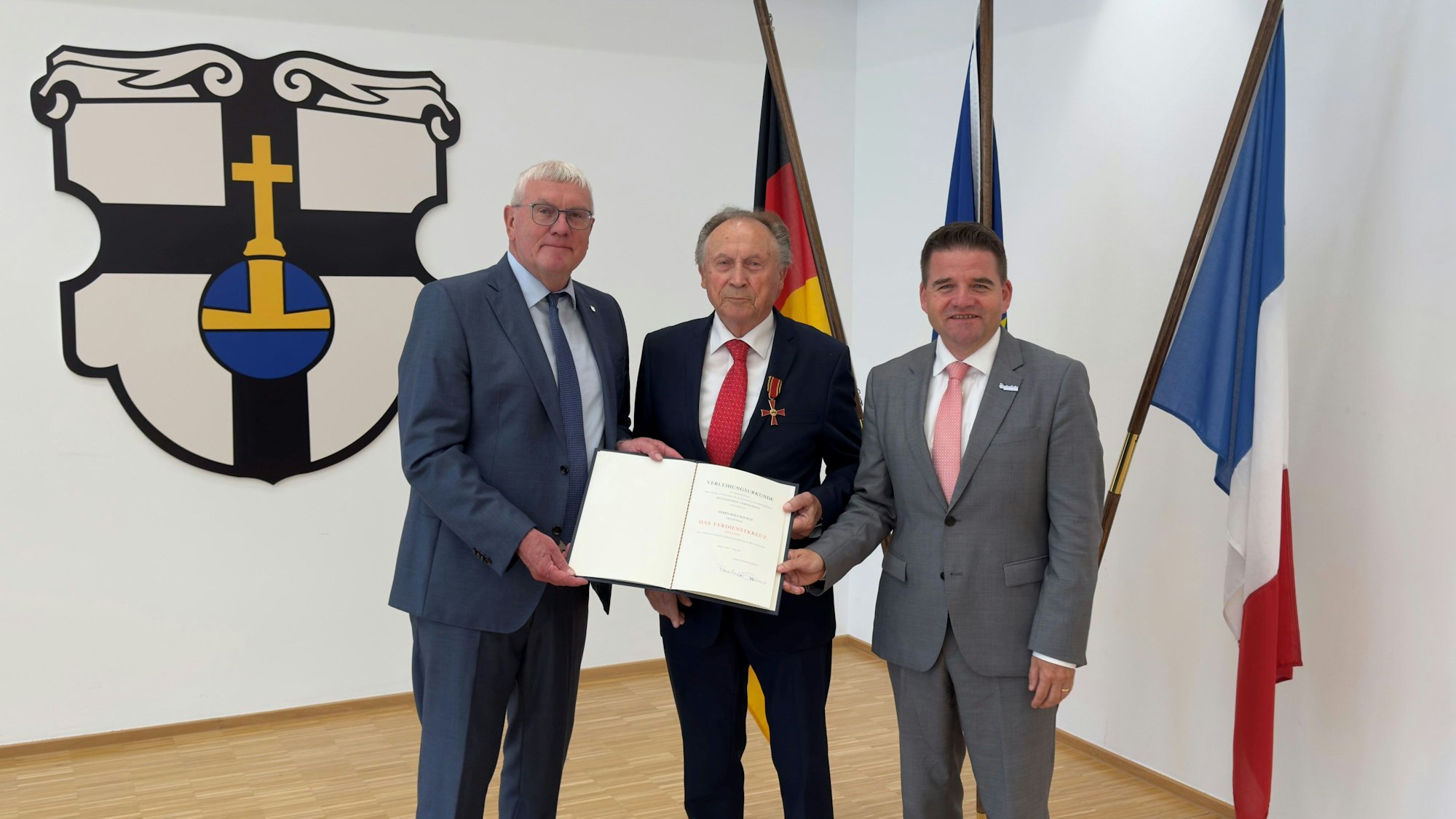 Landrat Sebastian Schuster (l.) überreichte das Bundesverdienstkreuz am Bande an Rolf Bausch, Holger Jung gratulierte.