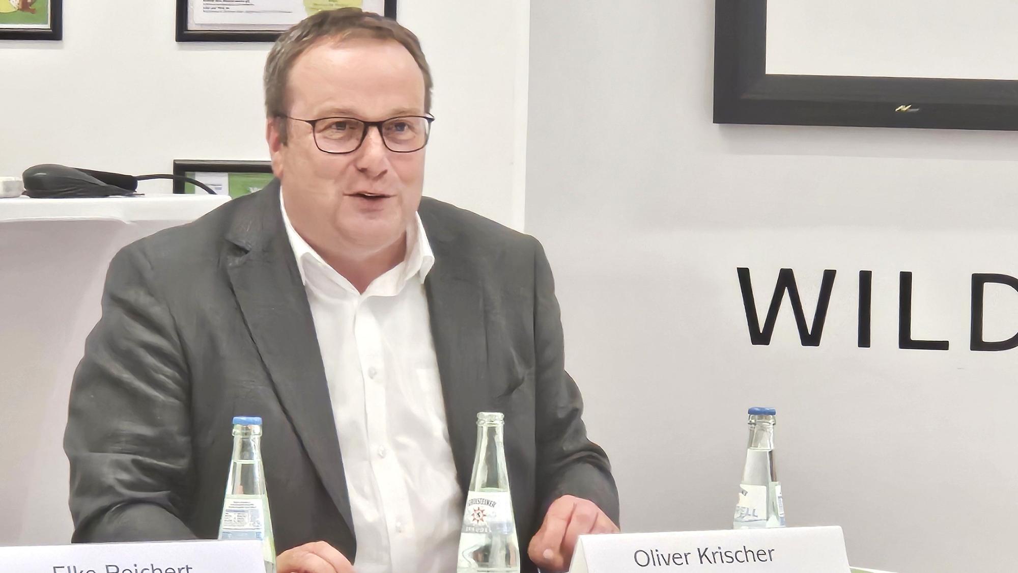 Oliver Krischer sitzt an einem Tisch und redet.