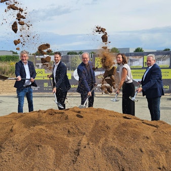 Zu sehen sind mehrere Personen mit Spaten an einem Erdhaufen.