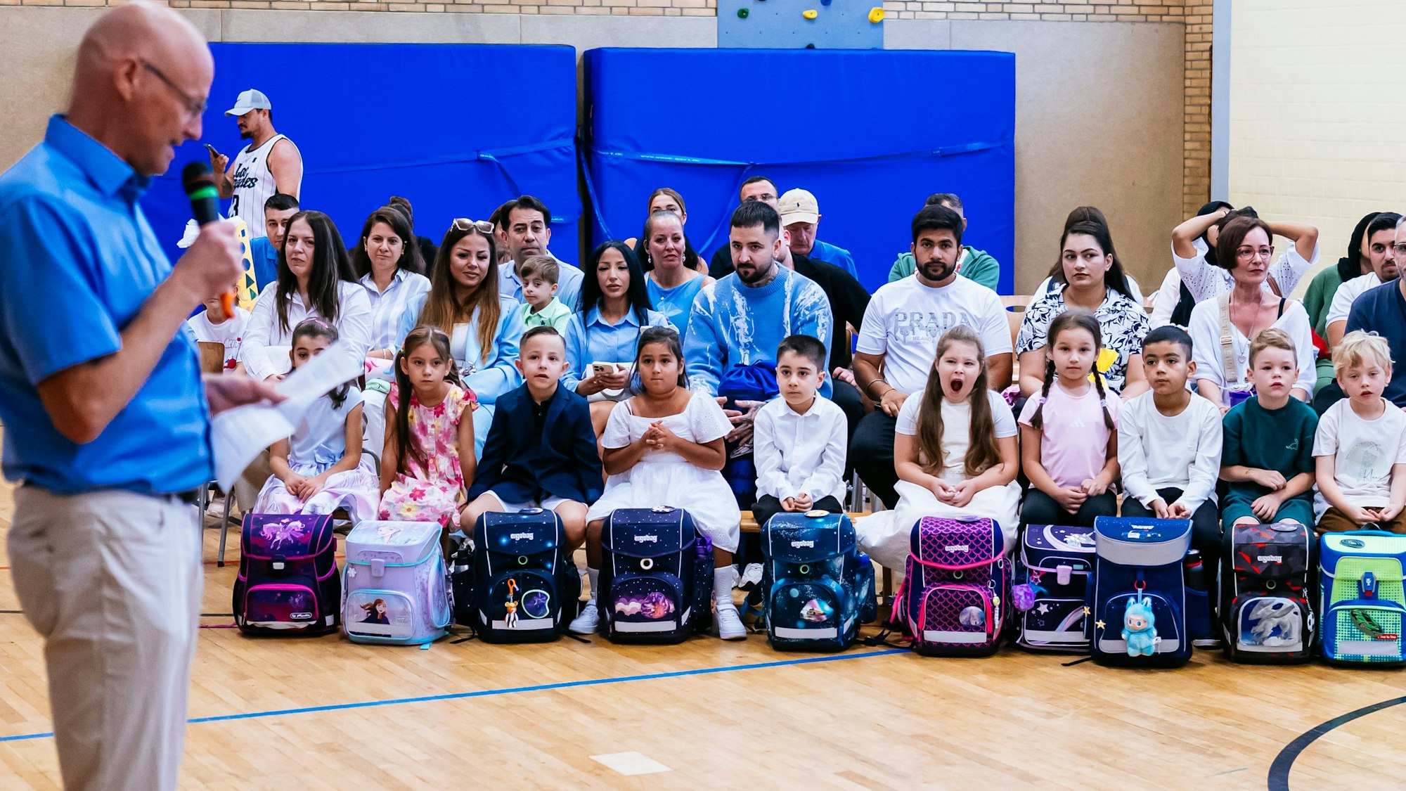 In der ersten Reihe sind i-Dötzchen aufgereiht und hören (teilweise) dem Lehrer zu.