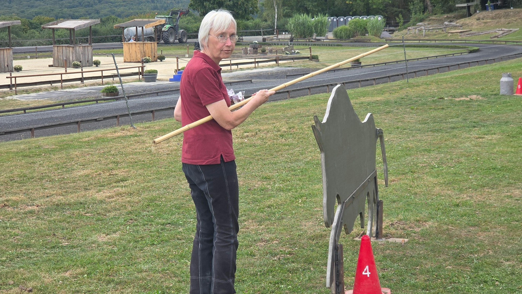 Gertrud Fahlbusch demonstriert den Hindernis-Parcours. Mit dem Stock muss ein Ring auf dem Stier-Aufsteller aufgesammelt werden.