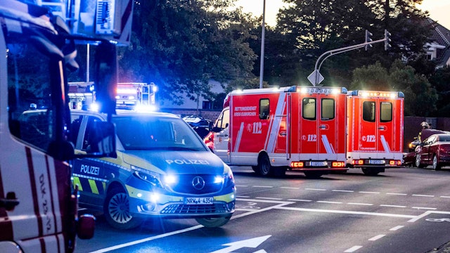 Im Vordergrund des Symbolbildes stehen Polizeiautos an einer Kreuzung, im Hintergrund Rettungswagen.