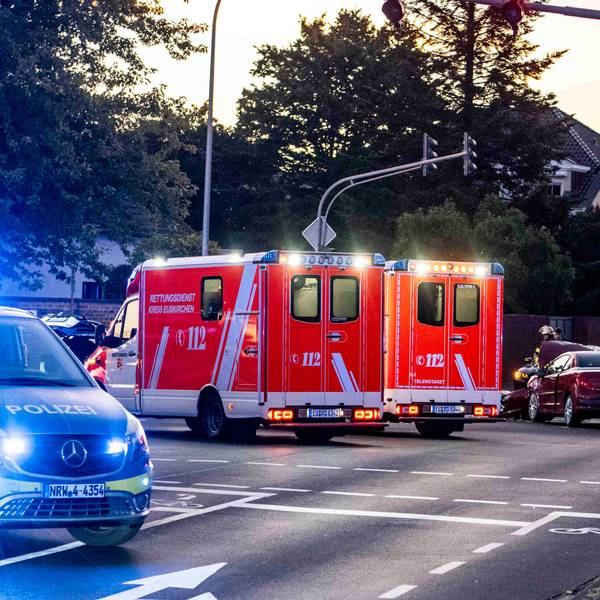 Im Vordergrund des Symbolbildes stehen Polizeiautos an einer Kreuzung, im Hintergrund Rettungswagen.
