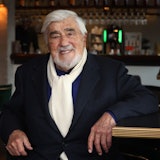 Mario Adorf lacht in einer Bar.
