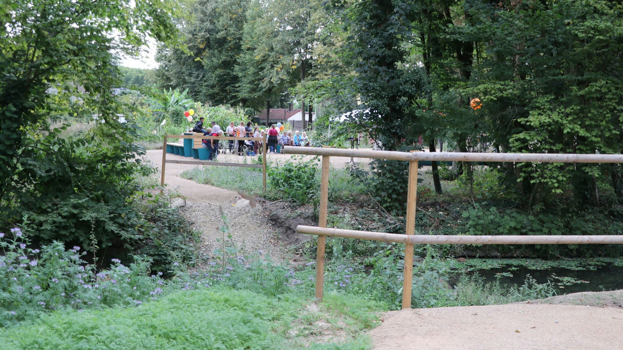 Zu sehen ist ein Schlosspark mit Besuchern.