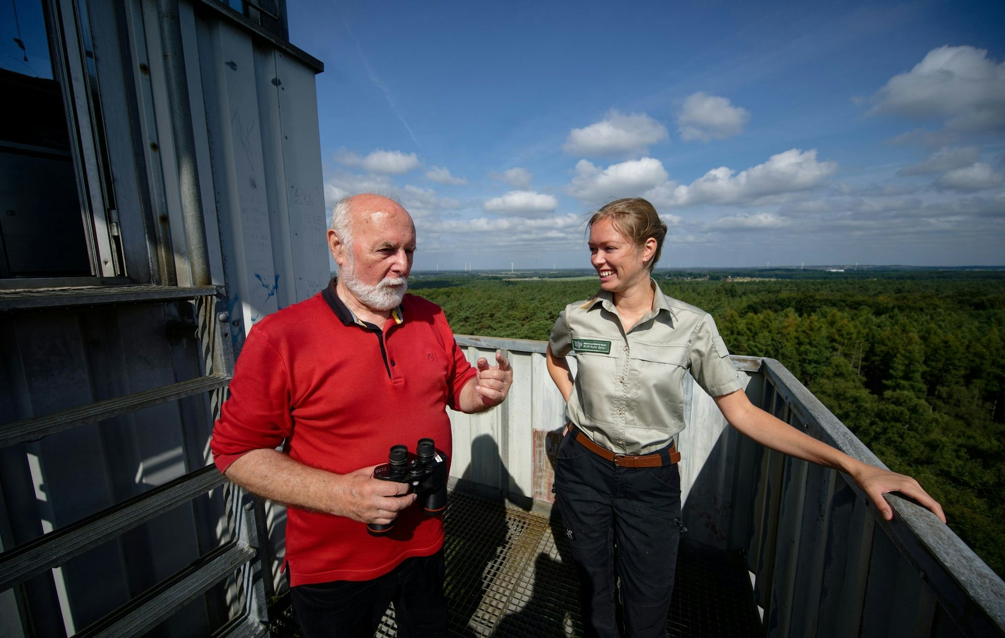 Feuerwächter Rudolf Hoffmann im Gespräch mit Försterin Carla Paul auf dem Feuerwachturm Galgenberg in Nordrhein-Westfalen.