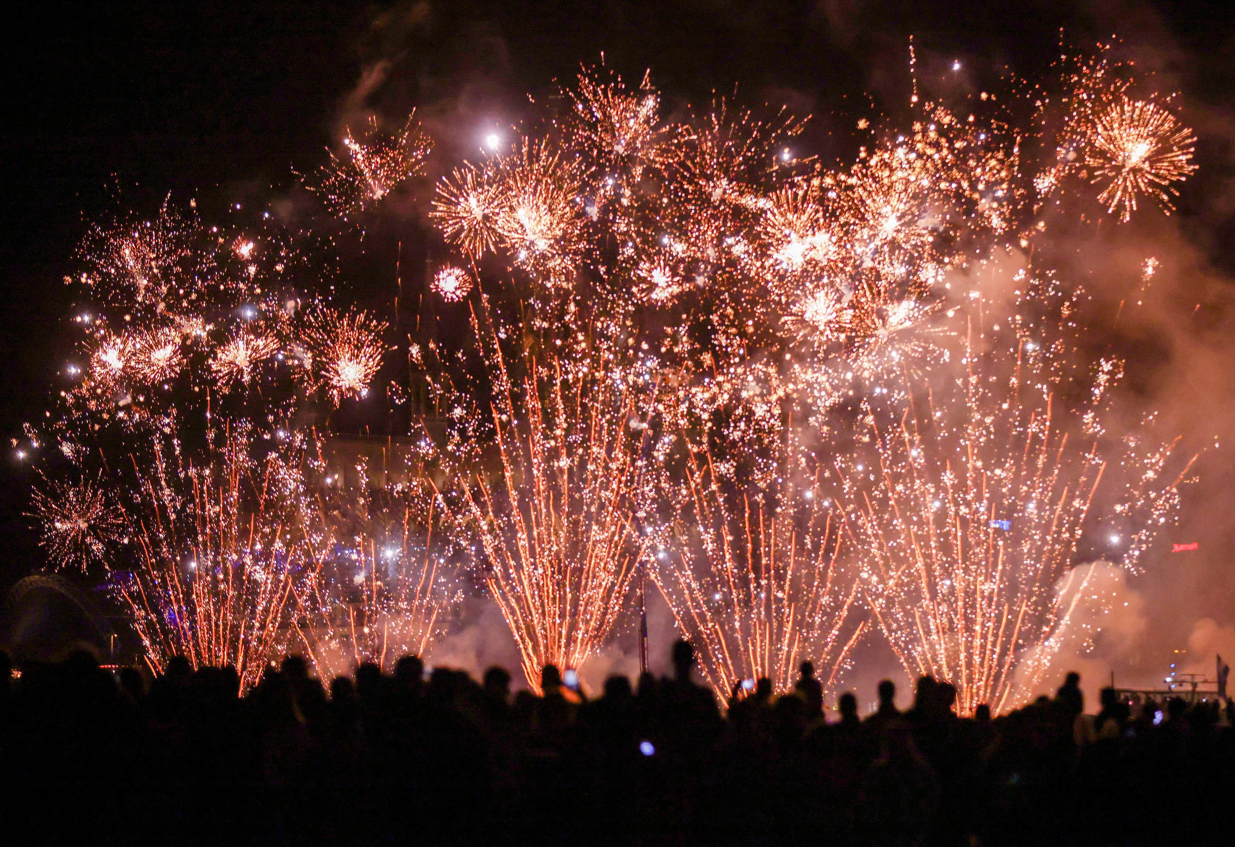 Menschen besuchen im Kölner Rheinpark das größte musiksynchrone Feuerwerk Europas.