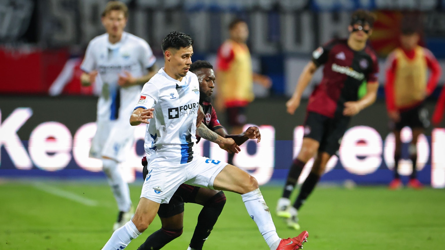 Mickael Biron (M, 1. FC Nürnberg) und Raphael Obermair (SC Paderborn 07, l) kämpfen am Freitag im Zweitligaspiel um den Ball.